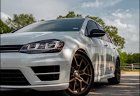 a white volkswagen golf r parked on a road