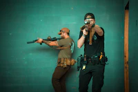 two men with guns in a room